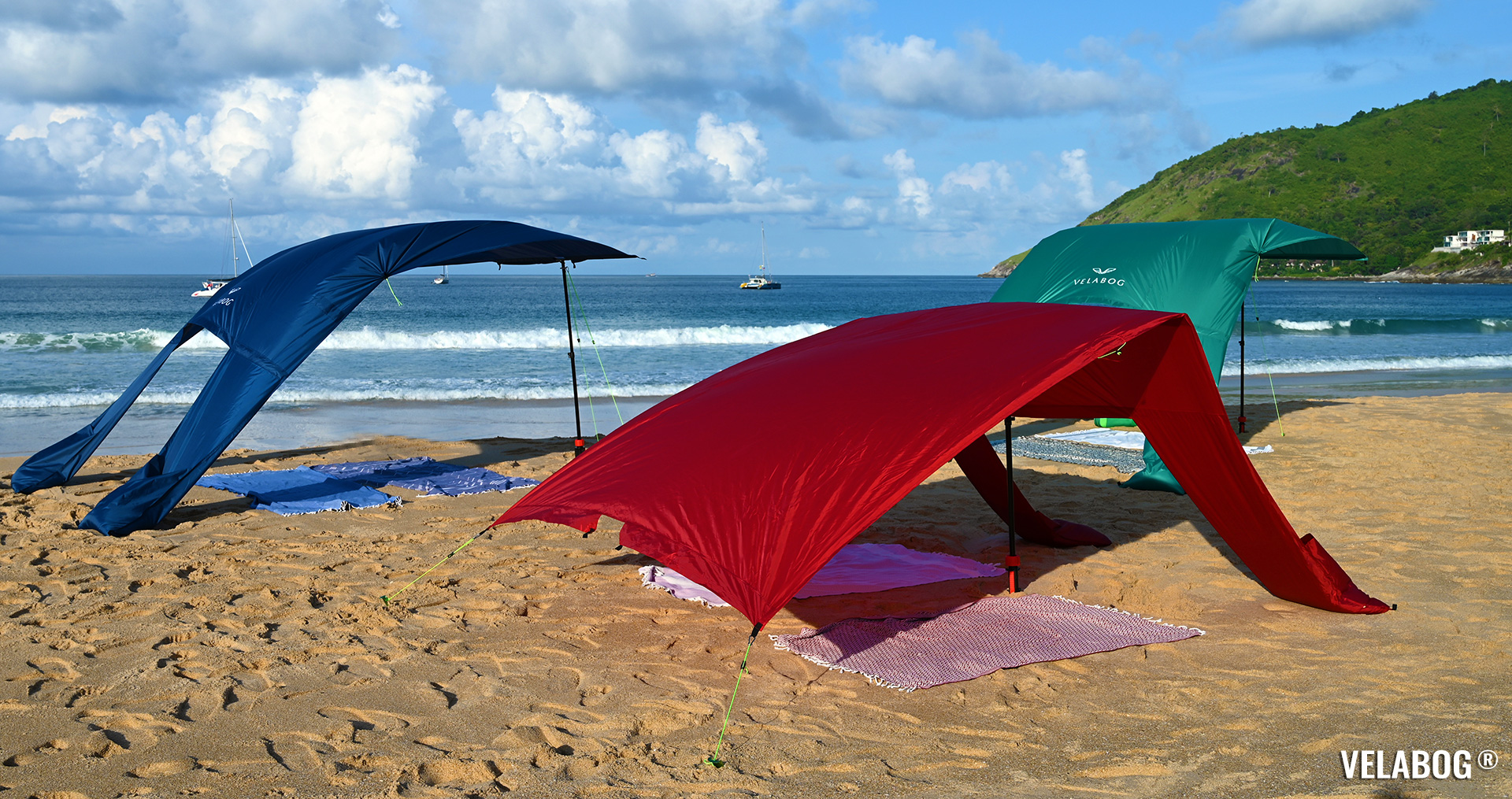Three beach sun sails Velabog Breeze on windy beach shows different setup options, beach canopy with best wind stability. View from the side.
